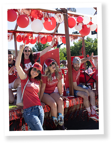 People dressed in red sitting on a trailer