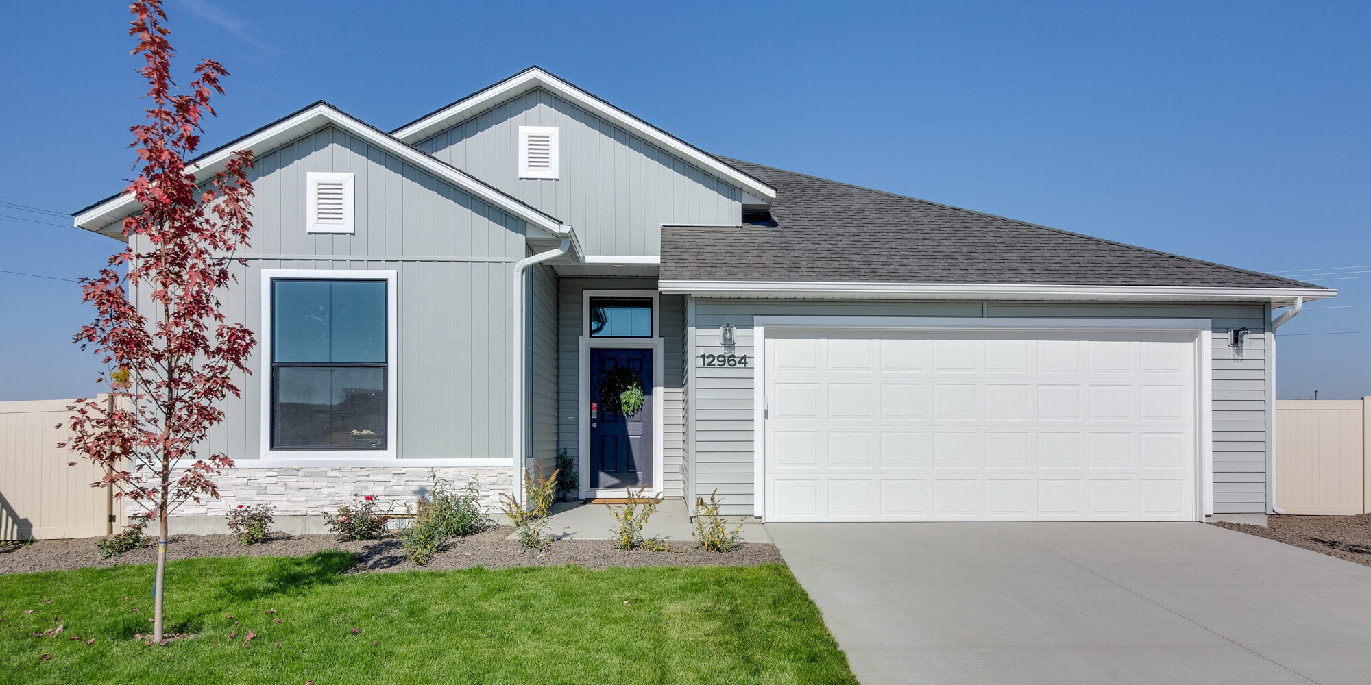 Stunning new home with modern design, featuring a spacious two-car garage, stylish exterior finishes, and beautiful landscaping—an example of the quality and craftsmanship coming soon to Wild Blue.
